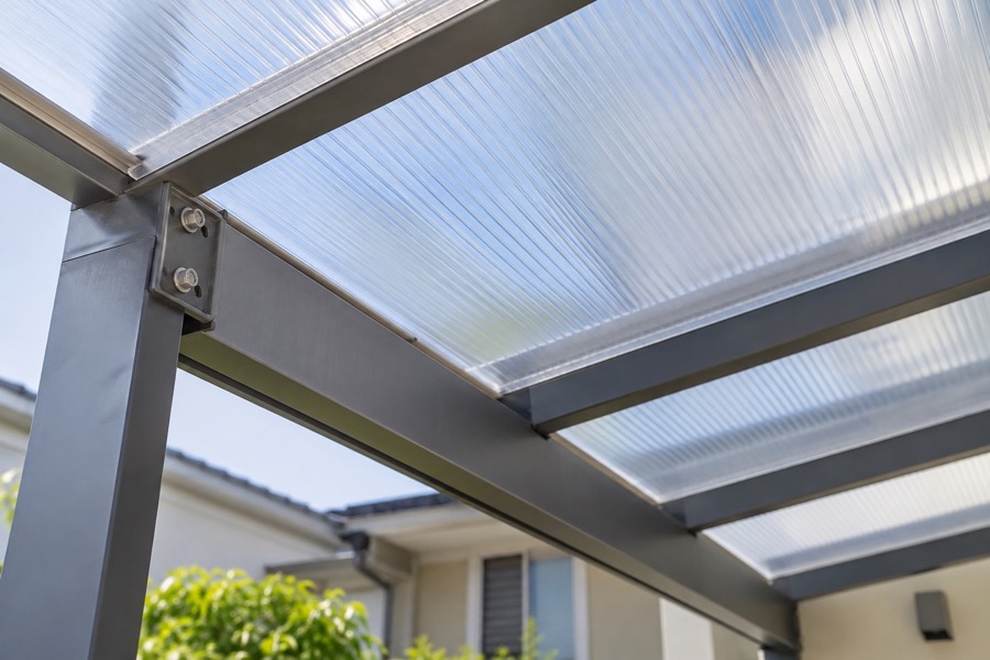Close-up of translucent polycarbonate roof panel edges and metal support beam with neat fixings