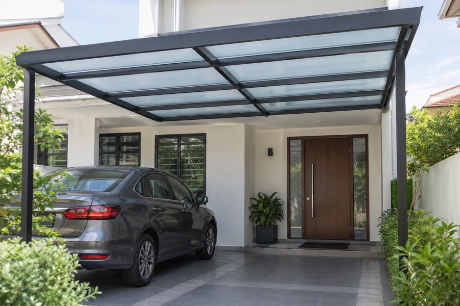 Modest covered porch entrance showing a parked car and a clear walkway to the front door