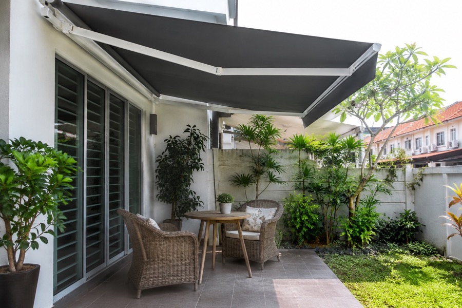 Fabric awning shading a small garden sitting area